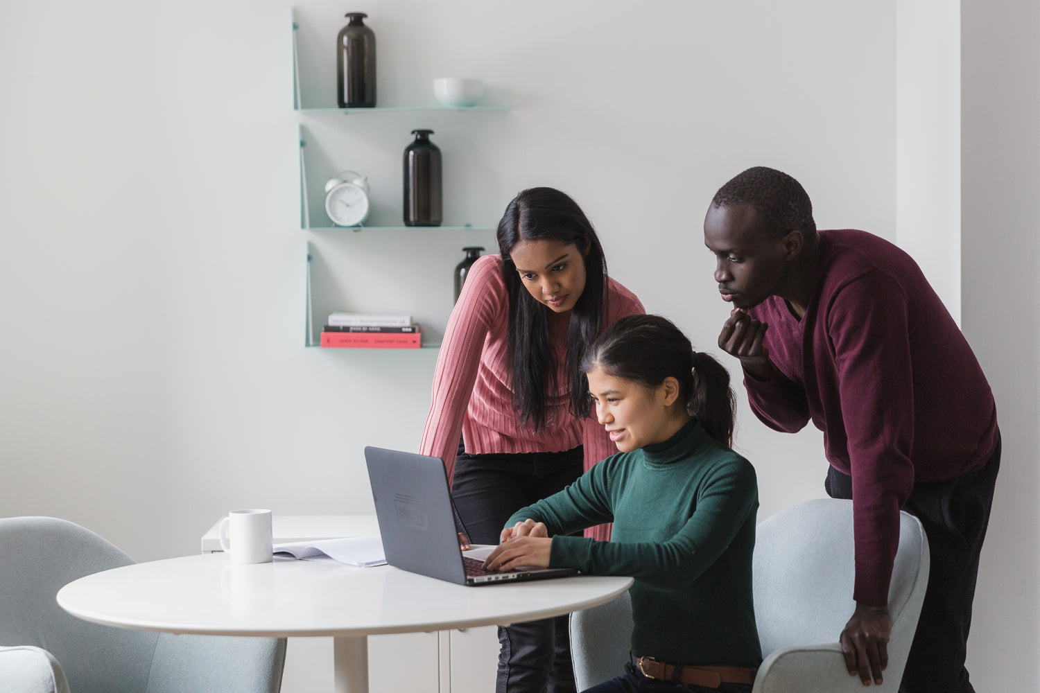 Three people watching together at a laptop 